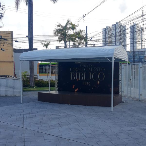 Tenda branca montada diante de palco para evento