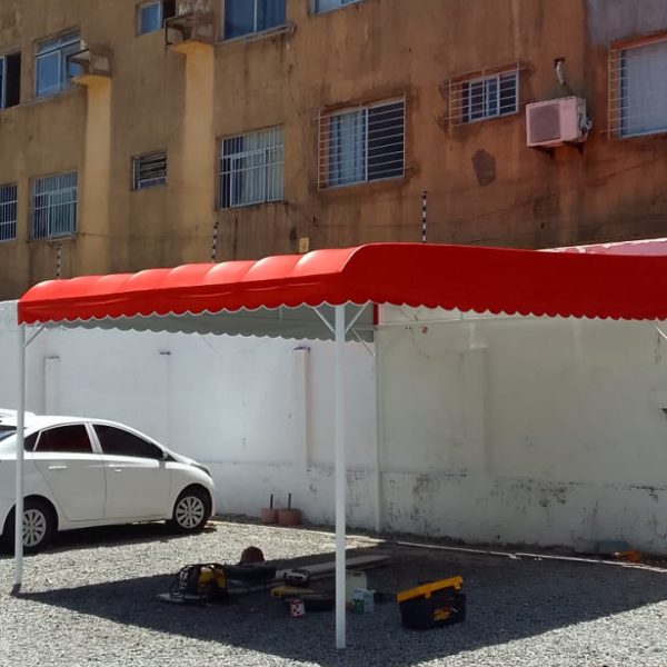 Cobertura vermelha ampla montada em área de estacionamento