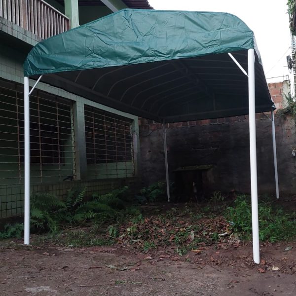 Tenda verde instalada ao lado de uma residência