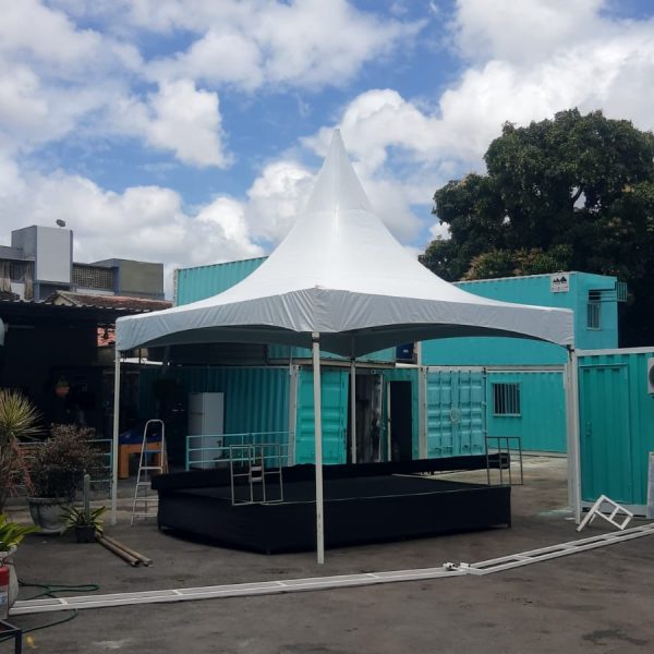 Tenda branca de pico montada sobre estrutura para evento